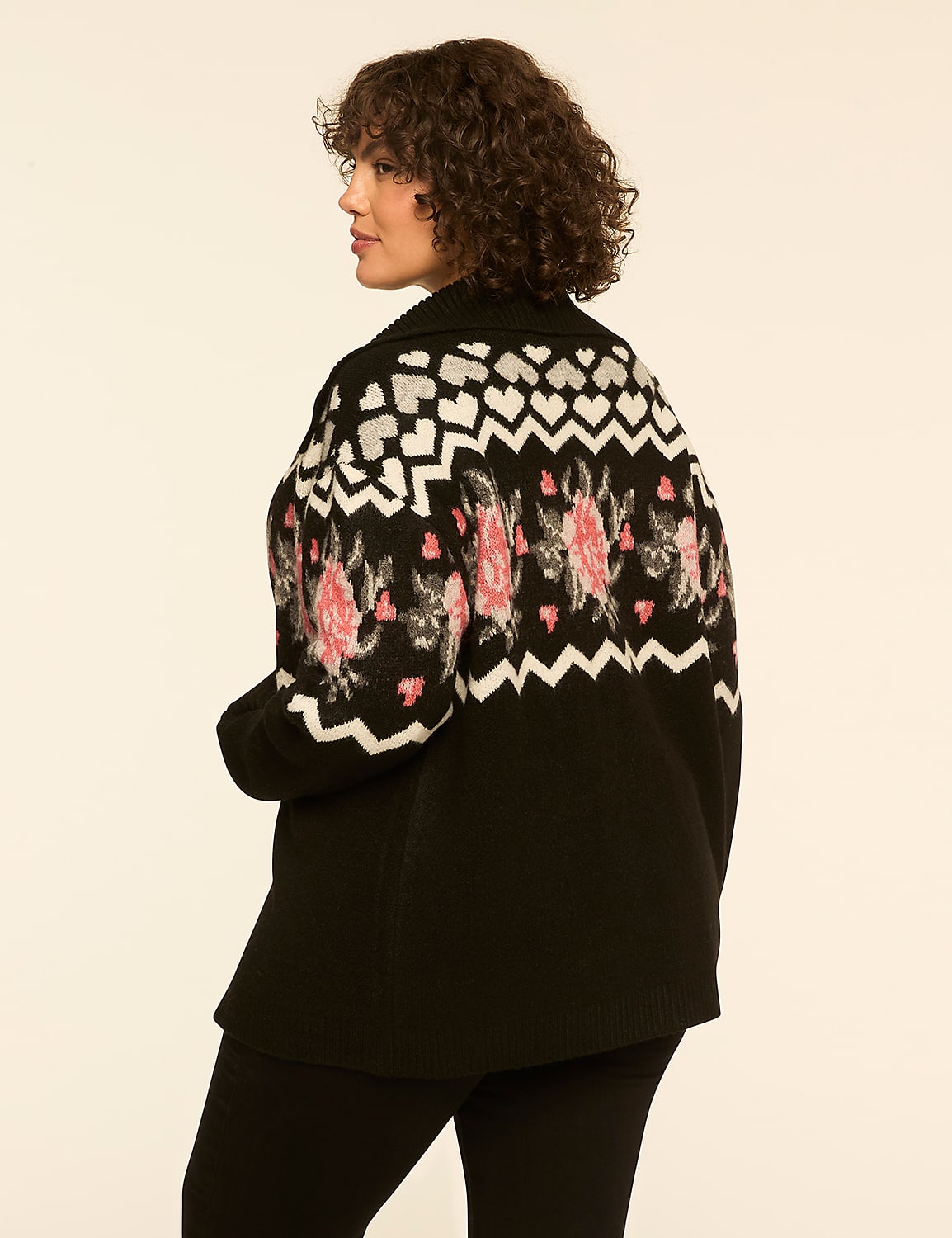 A woman with curly brown hair wearing a patterned black cardigan and black pants stands against a plain white background. Product Image 2