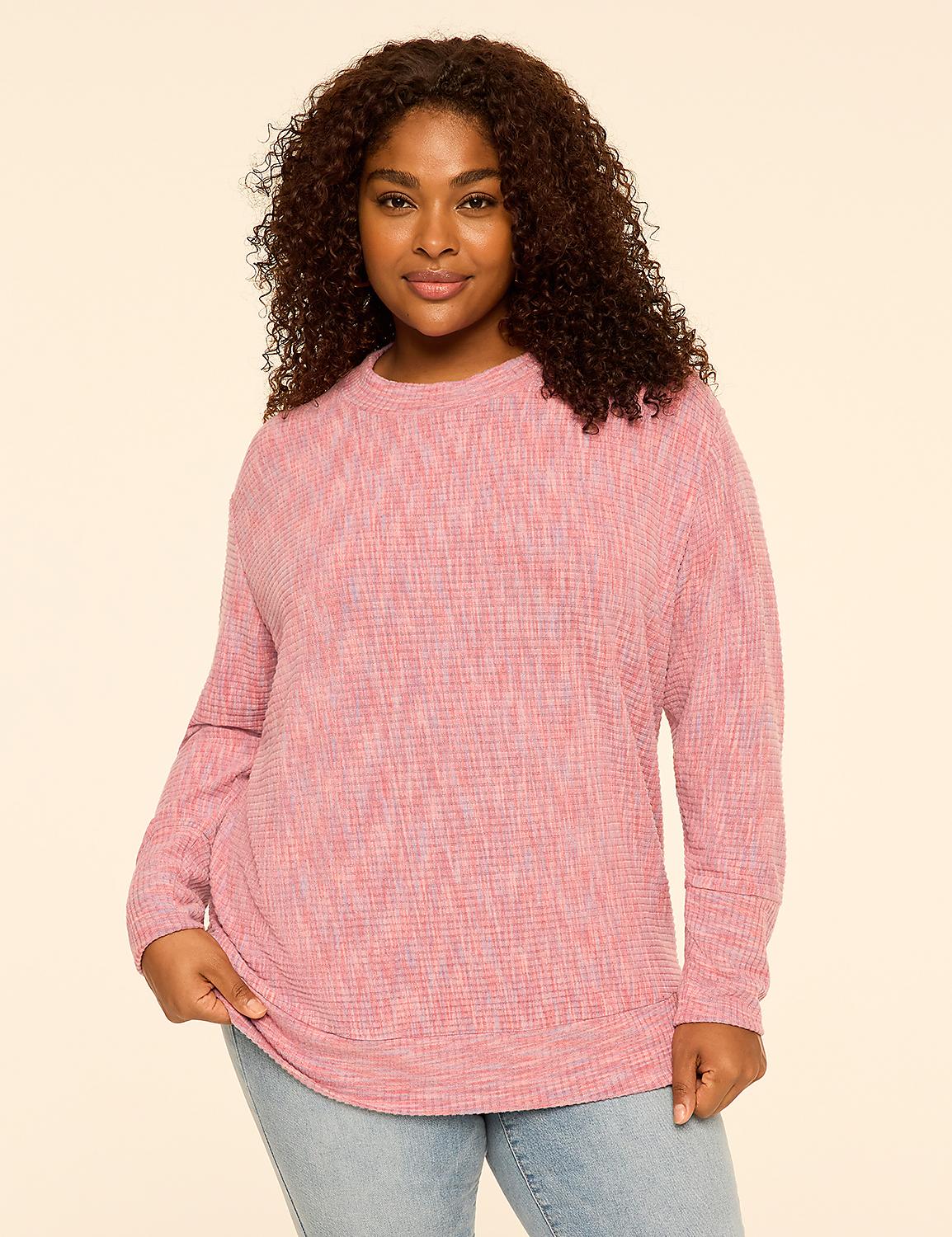 A woman with curly hair wearing a pink textured long-sleeve top and light blue jeans stands against a plain, light-colored background. Product Image 1