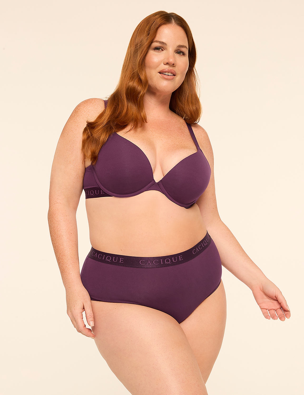A woman with red hair wearing a purple lingerie set stands against a plain, light-colored background. Product Image 4