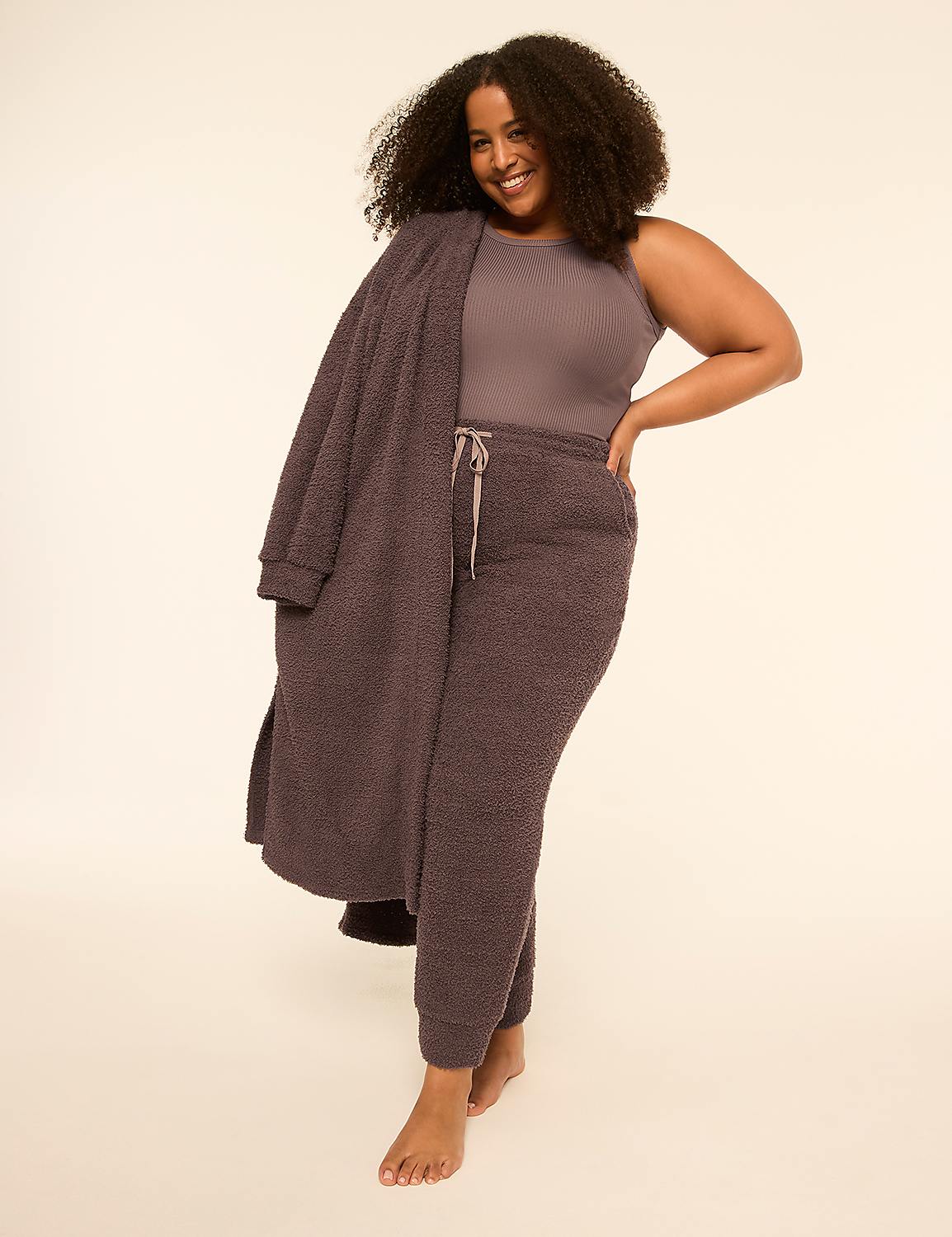 A smiling woman with curly hair wears a mauve ribbed top and matching fuzzy lounge pants with a long cardigan against a plain off-white background. Product Image 3