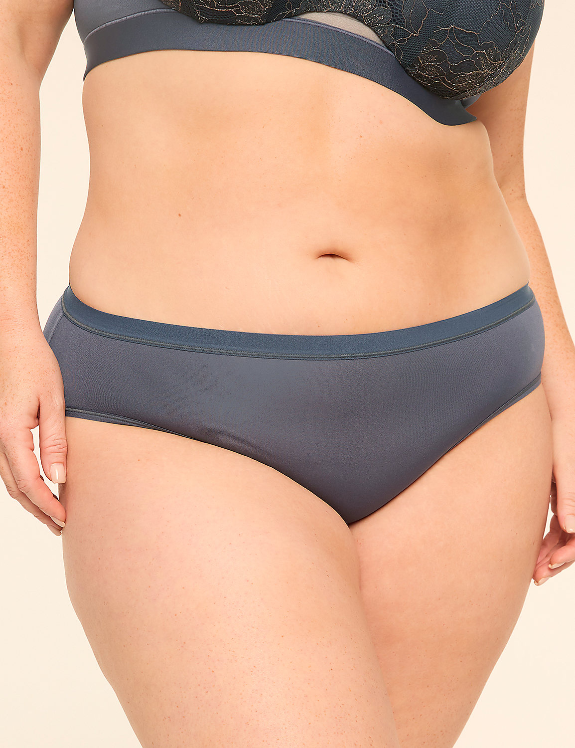 A woman wears a grey lingerie set against a plain, light-colored background. Product Image 1