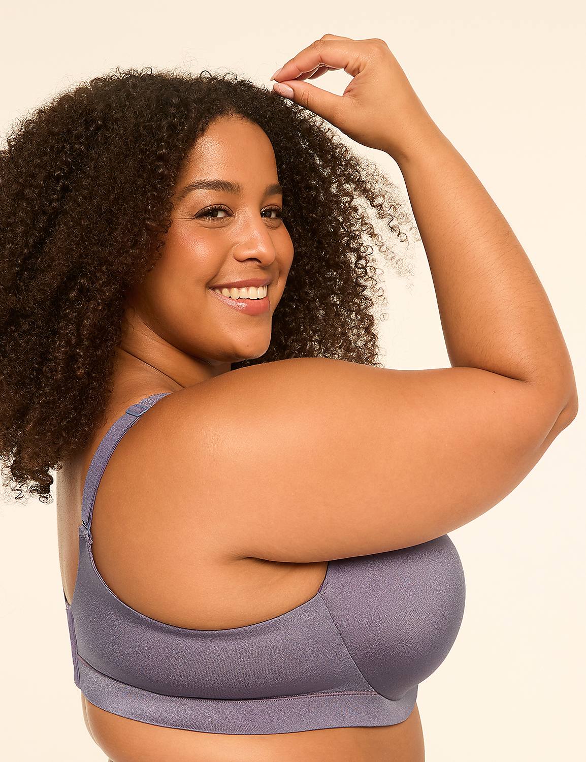 A smiling woman with curly hair wearing a purple bra poses against a plain, light-colored background. Product Image 3
