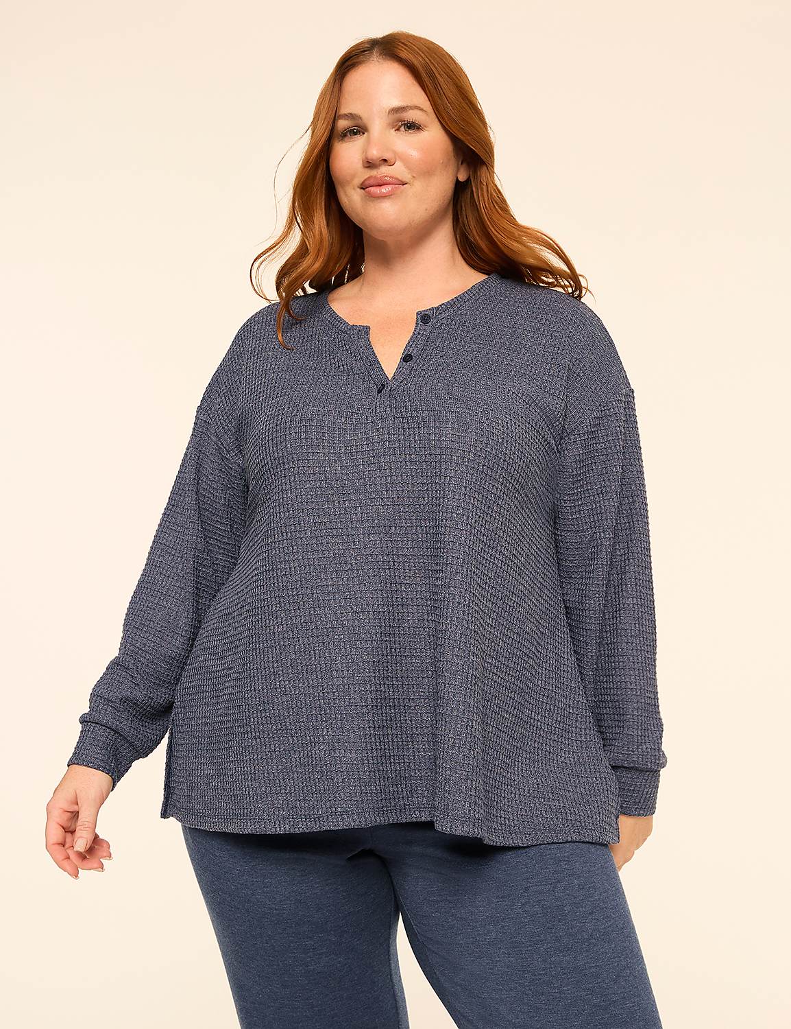 A woman with red hair wearing a blue textured long-sleeve top and matching pants stands against a plain, light-colored background. Product Image 1