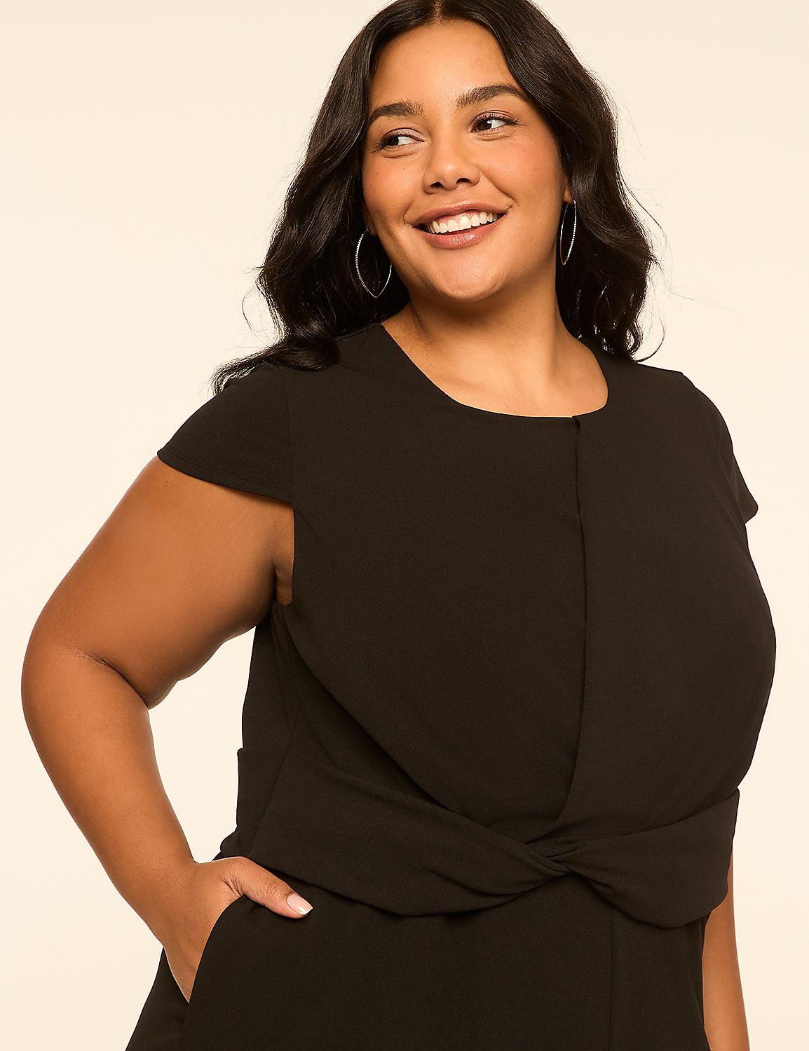 A smiling woman in a black jumpsuit poses against a plain, light-colored background. Product Image 3