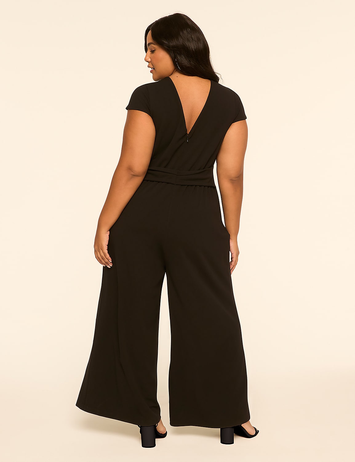 A woman in a black jumpsuit stands against a plain, light-colored background. Product Image 2