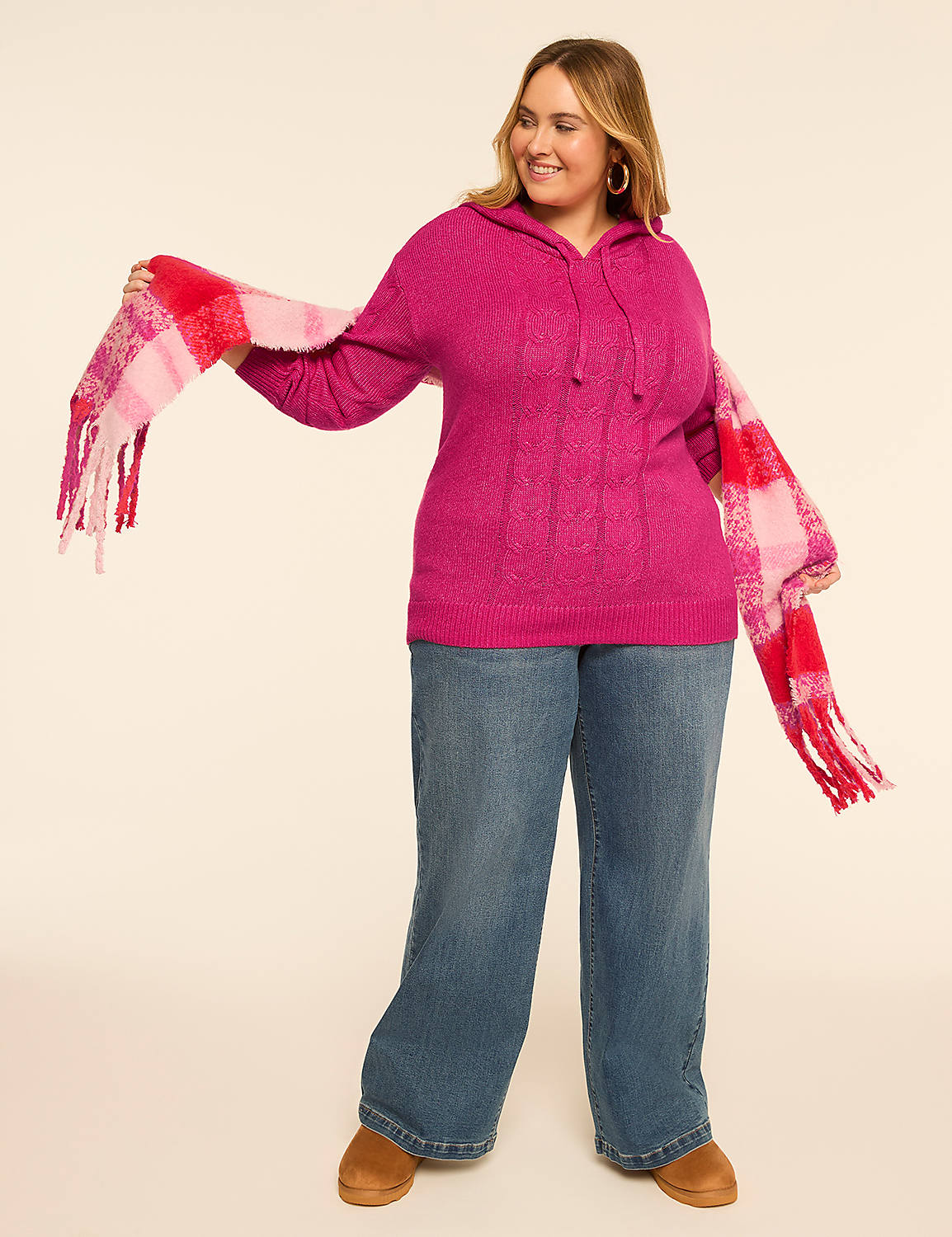 A woman in a pink cable-knit hoodie and wide-leg jeans poses with a red and pink plaid scarf draped around her, against a plain beige background. Product Image 3