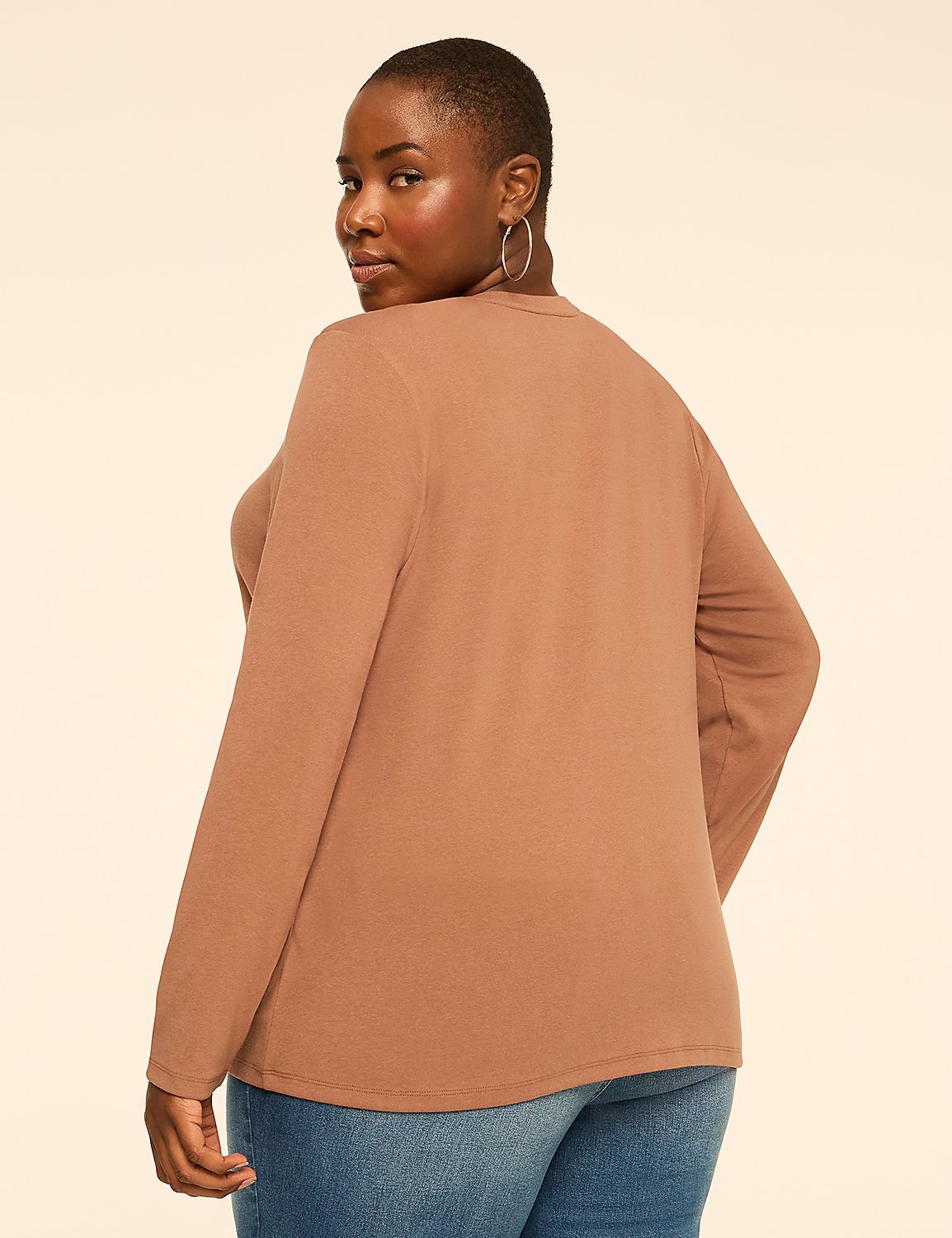 A woman wearing a brown long-sleeved top and blue jeans stands against a plain, light-colored background. Product Image 2