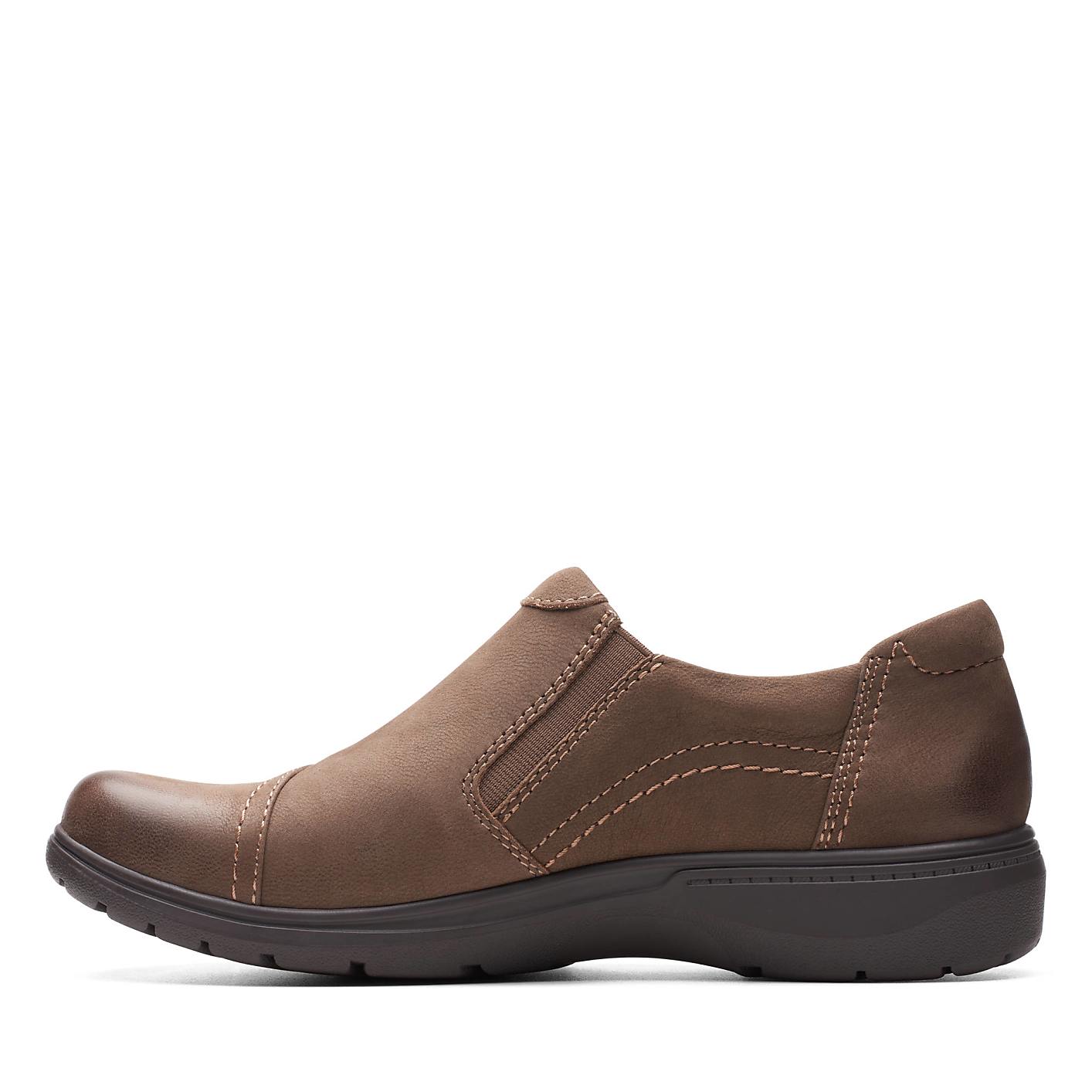 A brown leather slip-on shoe sits in the foreground against a plain white background. Product Image 2