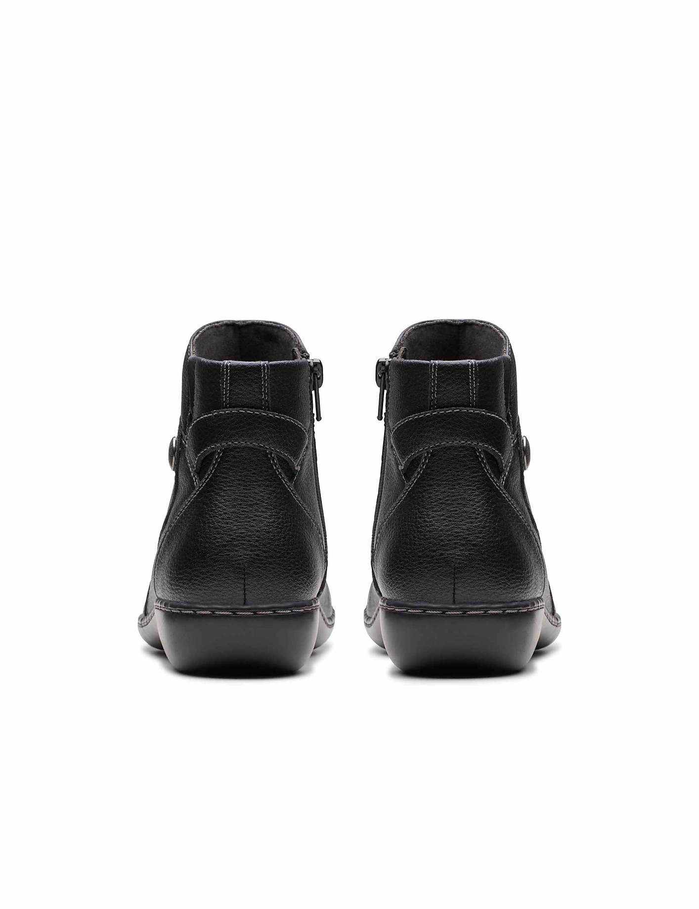 A pair of black leather ankle boots are positioned in the foreground against a plain white background. Product Image 2