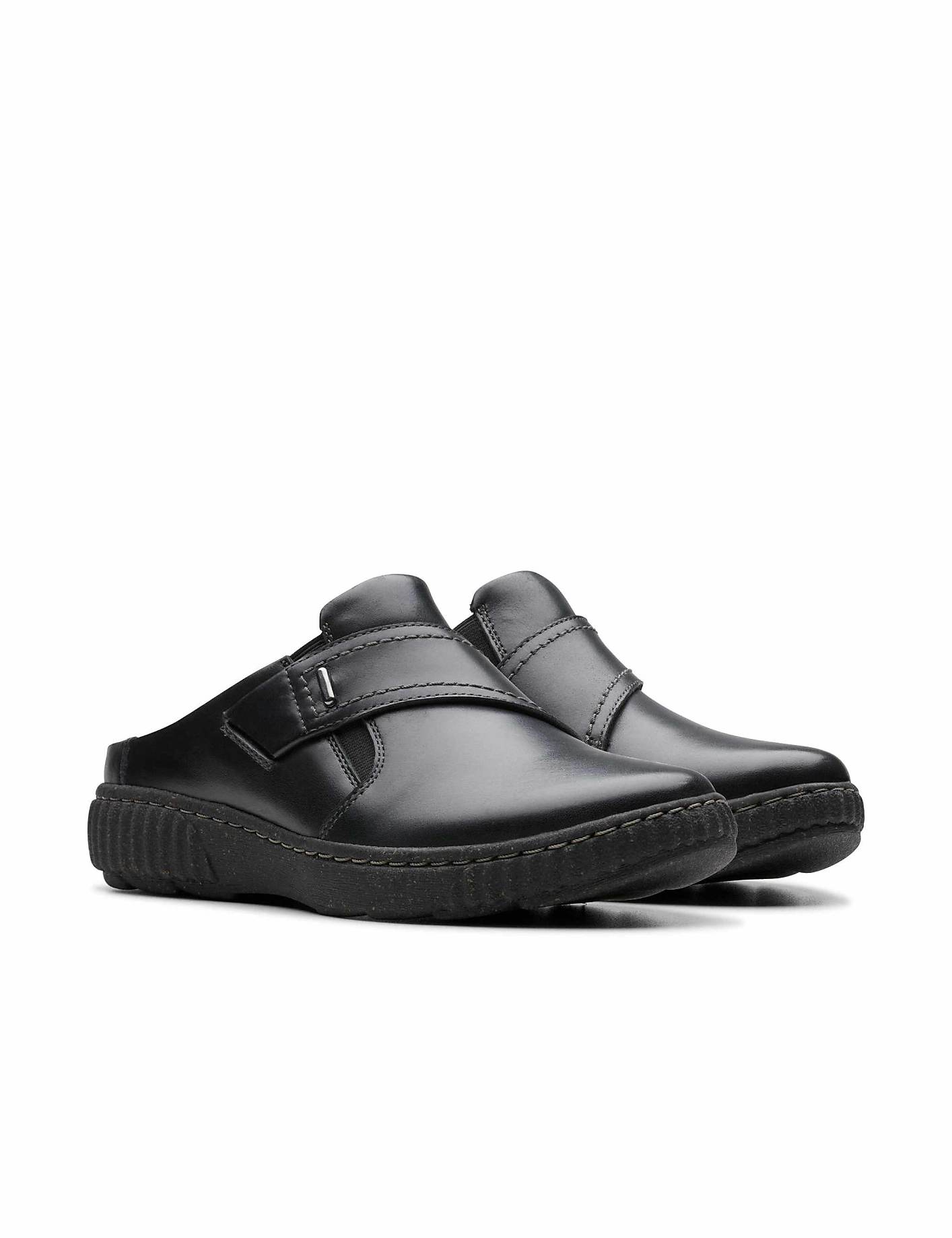 A pair of black leather slip-on shoes sits in the foreground against a plain white background. Product Image 5