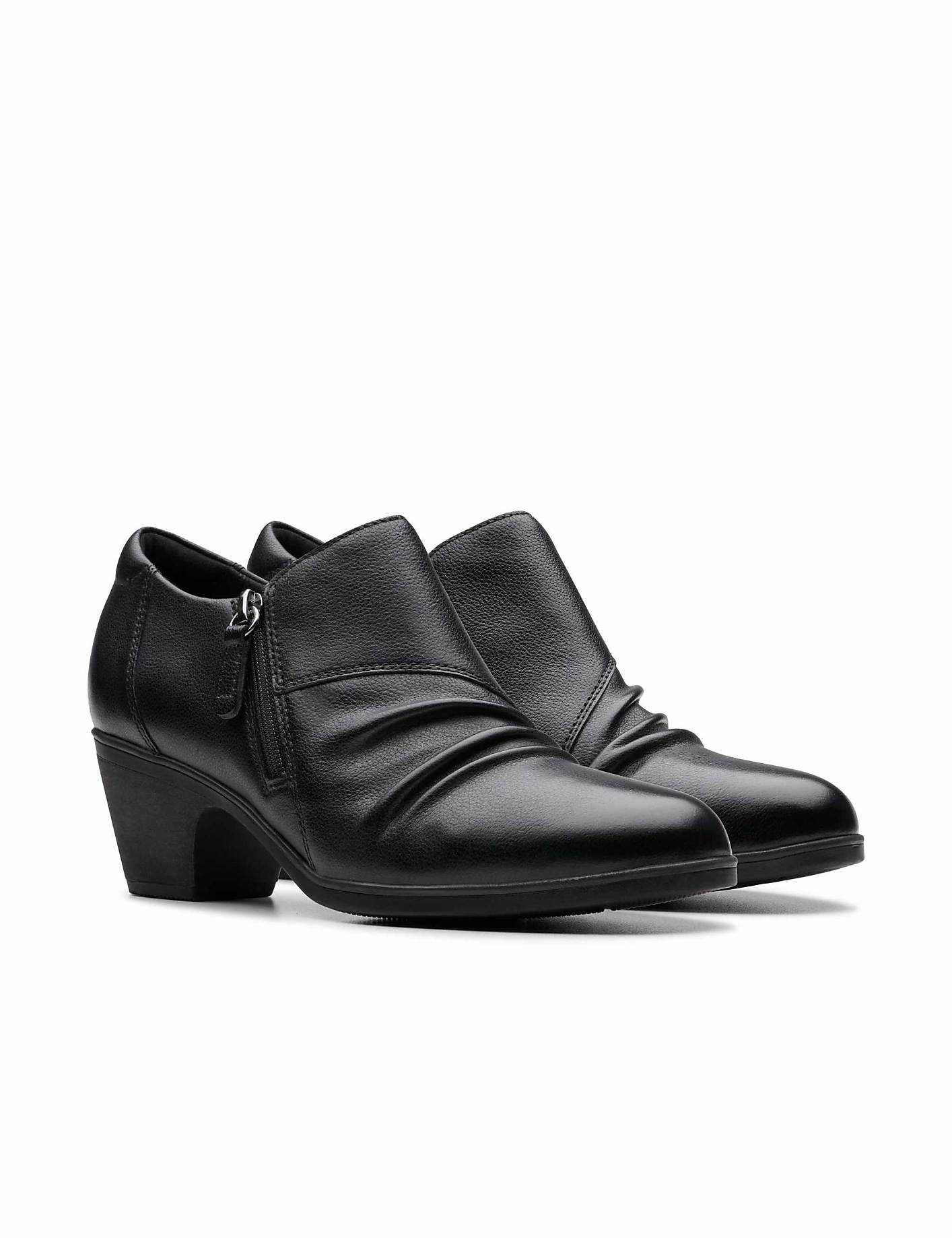 A pair of black leather ankle boots with a chunky heel sits against a plain white background. Product Image 5