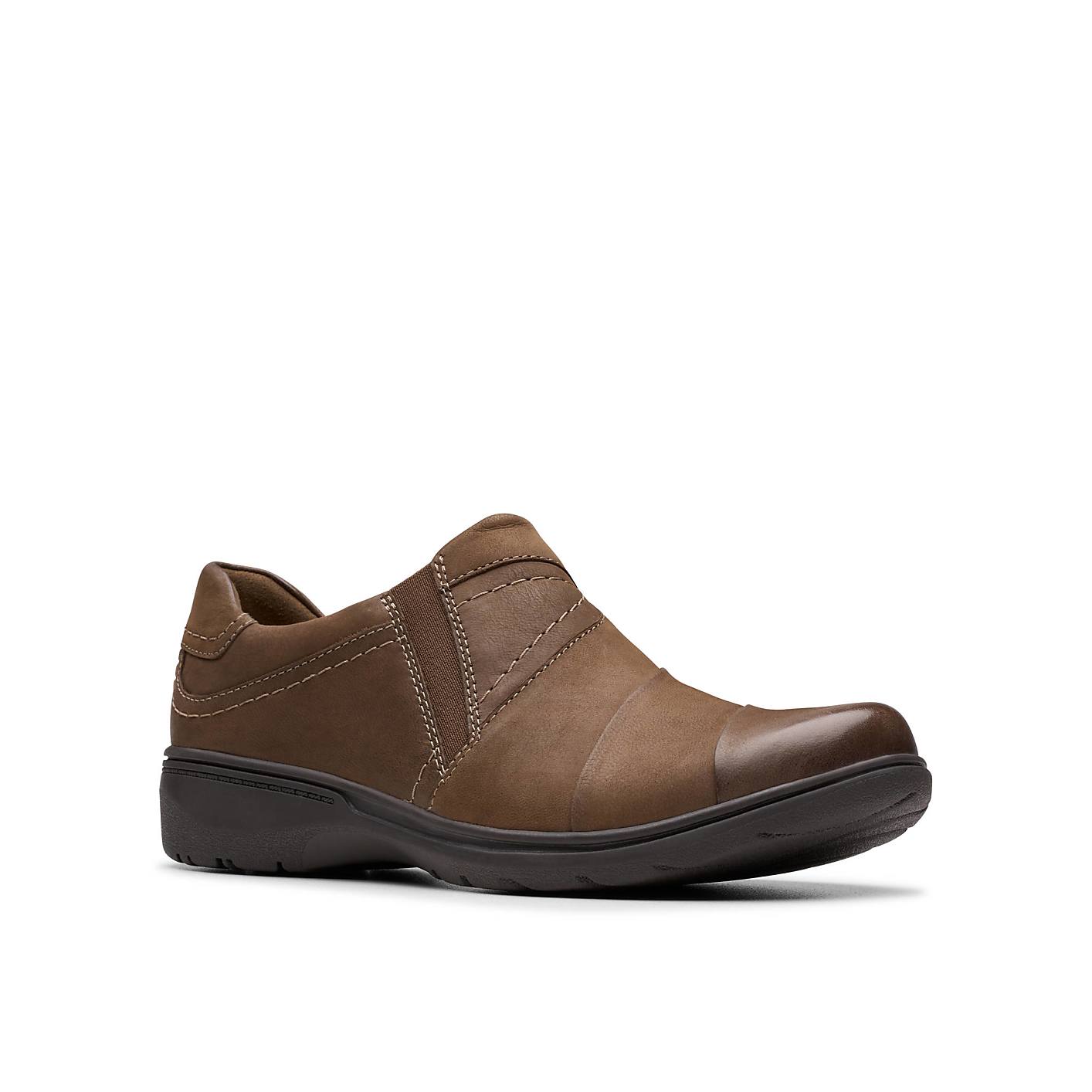 A brown leather slip-on shoe sits in the foreground against a plain white background. Product Image 5