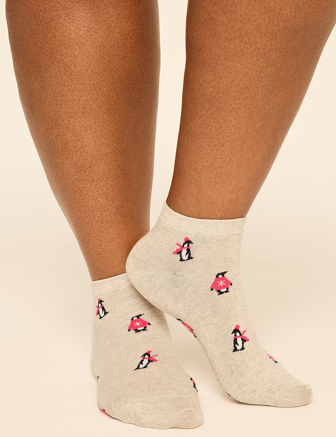 A person wears beige socks featuring small penguin patterns against a plain, light-colored background. Product Image 3